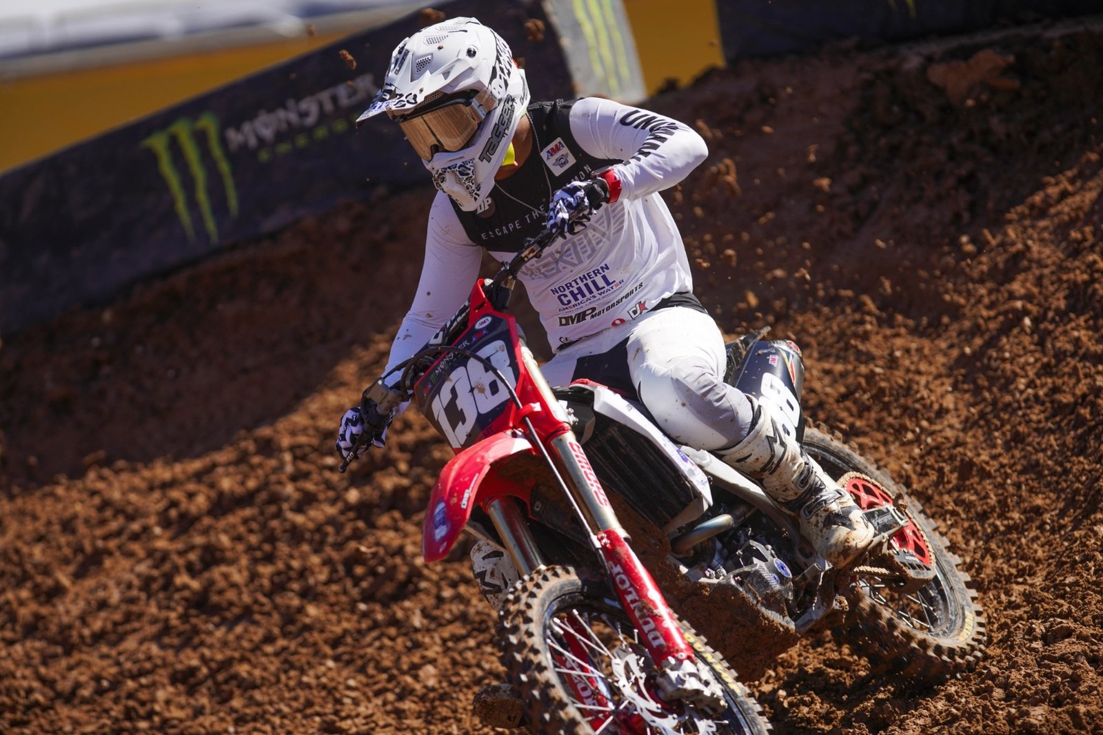 David Pulley number 138 racing a Honda CRF250R, Northern Chill America's Water and DMP Motorsports across the chest, Monster Energy Supercross banner behind.